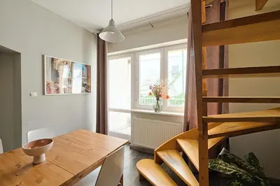 a dining room with a wooden table and a window at Urban Nest Apartments Radziwiłłowska 14 in Kraków