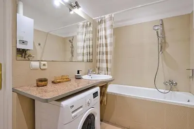 a bathroom with a sink and a washing machine at Urban Nest Apartments Radziwiłłowska 14 in Kraków
