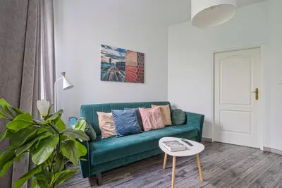 a living room with a green couch and a table at Urban Nest Apartments Radziwiłłowska 14 in Kraków