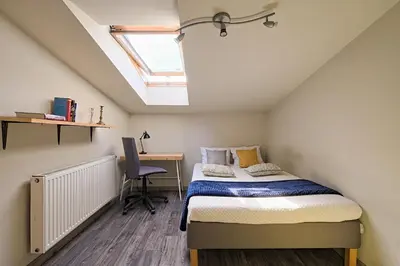 a bedroom with a bed and a desk and a window at Urban Nest Apartments Radziwiłłowska 14 in Kraków