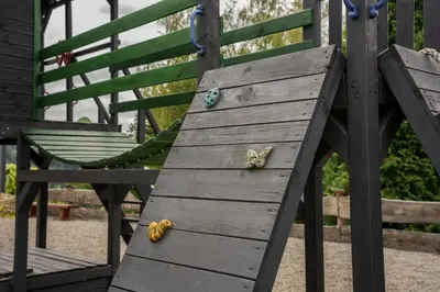 a playground with a wooden gazebo and a swing at Domek z bali drewnianych w górach Jacuzzi & Balia - Osada Chełm in Stróża
