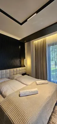a bedroom with two beds with white sheets and a window at Lake Park in Zator