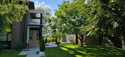a building with a yard with trees next to it at Lake Park in Zator