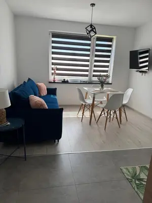 a living room with a blue couch and a table at Apartamenty Happy House in Zator