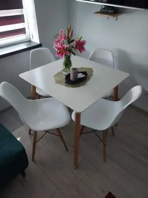 a white table with two chairs and a vase with flowers at Apartamenty Happy House in Zator