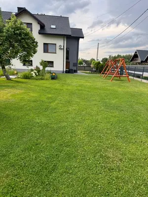 a large yard with a playground in front of a house at Apartamenty Happy House in Zator