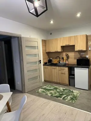 a kitchen with wooden cabinets and a white refrigerator at Apartamenty Happy House in Zator