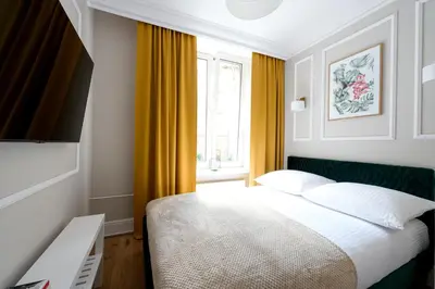 a hotel room with a bed and a window at Native Apartments Nowowiejska 9 Deluxe in Kraków
