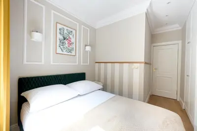 a bedroom with a white bed and a green headboard at Native Apartments Nowowiejska 9 Deluxe in Kraków