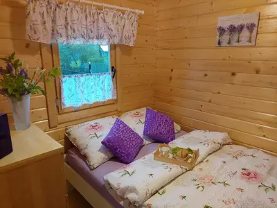 a small room with a bed in a log cabin at Domek Kalilla in Bachowice