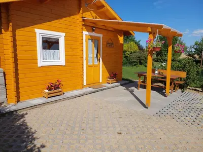 a small yellow house with a picnic table outside at Domek Kalilla in Bachowice