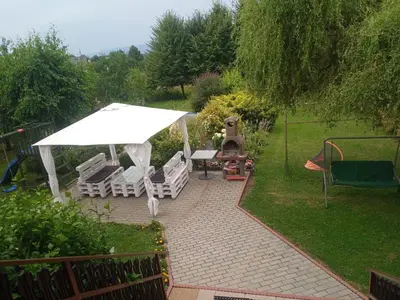 a backyard with a table and chairs and an umbrella at Domek Kalilla in Bachowice
