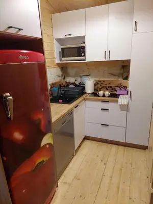 a small kitchen with white cabinets and a red refrigerator at Domek Kalilla in Bachowice