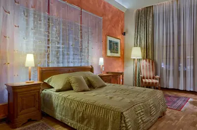 a bedroom with a bed and two lamps and a chair at Hotel Wentzl in Kraków