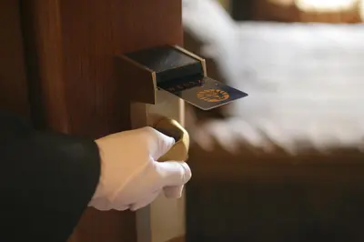 a person in white gloves unlocking a door at Hotel Wentzl in Kraków