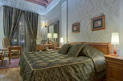 a bedroom with a bed and a living room at Hotel Wentzl in Kraków