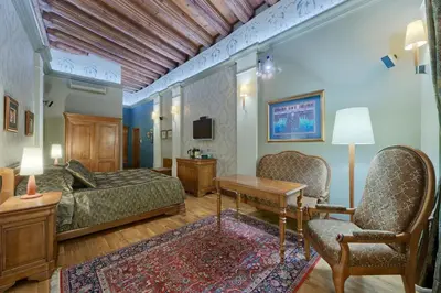 a hotel room with a bed and a table and chairs at Hotel Wentzl in Kraków