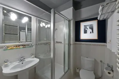 a bathroom with a shower toilet and a sink at Hotel Wentzl in Kraków
