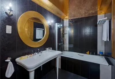a bathroom with a sink and a tub and a mirror at Hotel Wentzl in Kraków