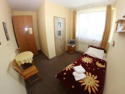 a bedroom with a bed and a desk and a window at Hotel Daisy Budget in Kraków