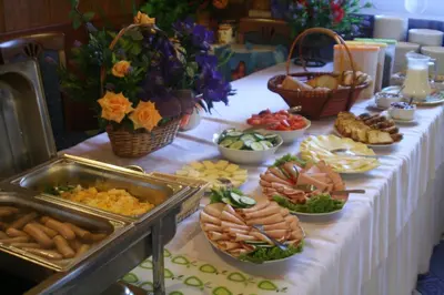 a table with a buffet of food on it at Hotel Daisy Budget in Kraków