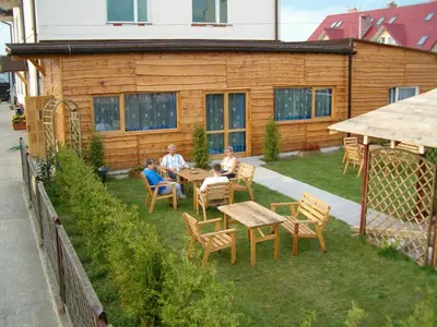 a group of people sitting at a table in a yard at Hotel Daisy Budget in Kraków