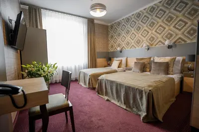 a hotel room with two beds and a flat screen tv at Hotel Kazimierz in Kraków