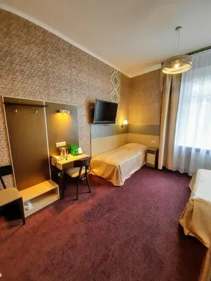 a hotel room with two beds and a television at Hotel Kazimierz in Kraków