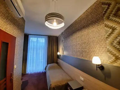 a hotel room with a bed and a large window at Hotel Kazimierz in Kraków