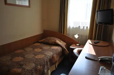 a hotel room with a bed and a television at Matejko Hotel in Kraków