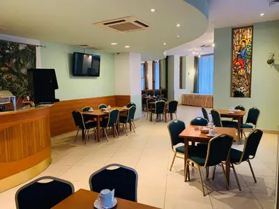 a restaurant with tables and chairs and a bar at Matejko Hotel in Kraków