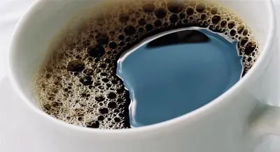 a cup of coffee with a blue liquid in it at Matejko Hotel in Kraków