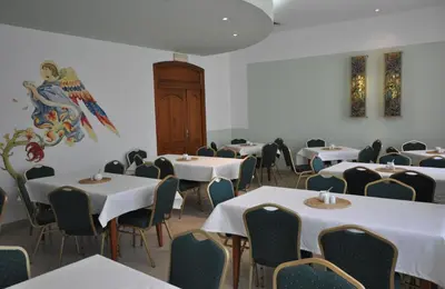 a room full of tables and chairs with white table cloth at Matejko Hotel in Kraków