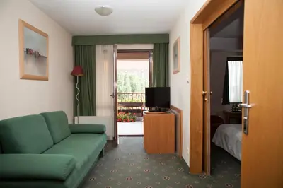a living room with a green couch and a television at Hotel Secesja in Kraków