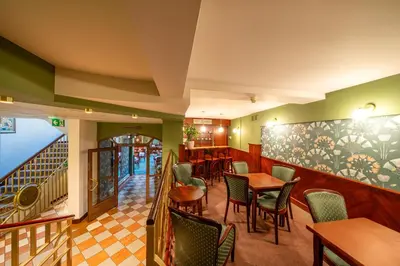 a restaurant with tables and chairs and a staircase at Hotel Secesja in Kraków