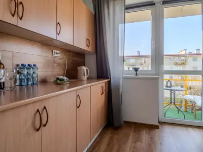 a kitchen with wooden cabinets and a large window at Wspomnienie młodości in Kraków