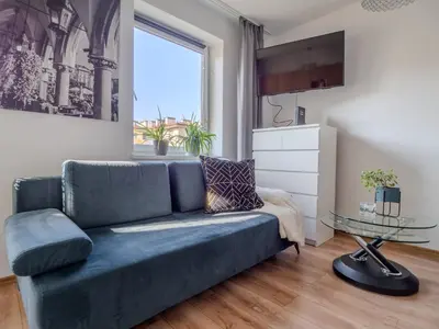 a living room with a blue couch and a glass table at Wspomnienie młodości in Kraków