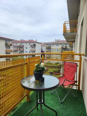 a patio with a table and a chair on a balcony at Wspomnienie młodości in Kraków