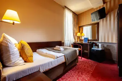 a bathroom with a sink and a bed in a room at Hotel Wielopole in Kraków