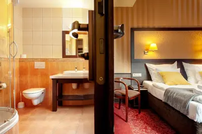 a hotel room with a bed and a bathroom at Hotel Wielopole in Kraków