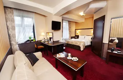 a hotel room with a bed and a couch at Hotel Wielopole in Kraków