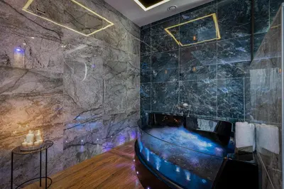 a bathroom with a stone wall and a tub at Stacja Galicja Rooms blisko Energylandia in Trzebieńczyce