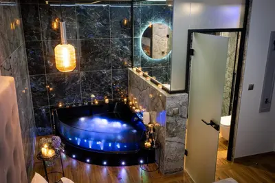 a bathroom with a blue tub with lights in it at Stacja Galicja Rooms blisko Energylandia in Trzebieńczyce