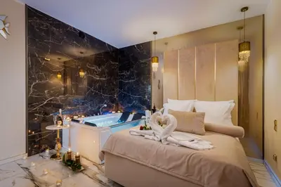 a bedroom with a tub and a bed with a swan decoration at Stacja Galicja Rooms blisko Energylandia in Trzebieńczyce