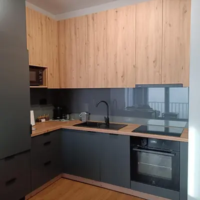 a kitchen with wooden cabinets and a sink and a stove at Apartament No 34 Green - Holiday Home Zator in Zator