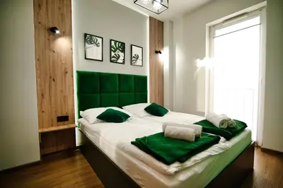 a bedroom with a large bed with green headboard at Apartament No 34 Green - Holiday Home Zator in Zator