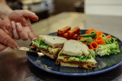 a sandwich and vegetables on a blue plate at Zajazd Srebrna Gora in Kraków