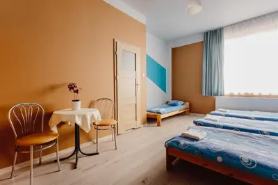 a bedroom with two beds and a table and chairs at Hostel Tara in Kraków