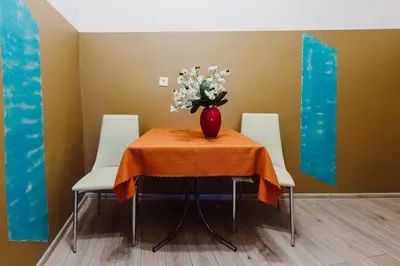 a vase of flowers sitting on a table with three chairs at Hostel Tara in Kraków