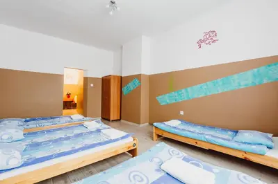 three beds in a room with blue and white at Hostel Tara in Kraków